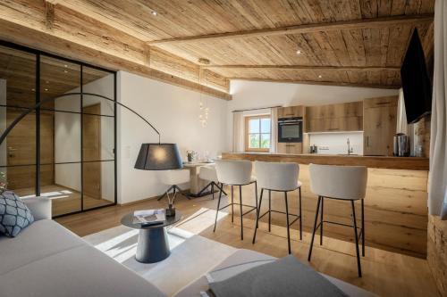 a living room with a couch and a kitchen at Arnestgut in Strobl