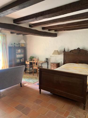 une chambre avec un lit, une table et des chaises dans l'établissement Maison de charme, à Malicorne-sur-Sarthe