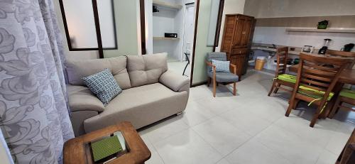 a living room with a couch and a kitchen at Oasis del Mar- Departamento Mar in Progreso
