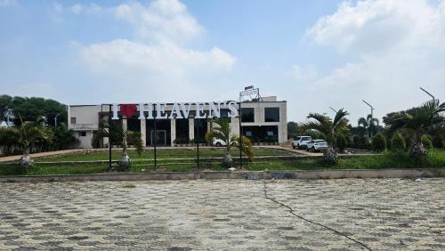 a building with a large sign in front of it at Heaven's Hotel &Resort in Ratlām