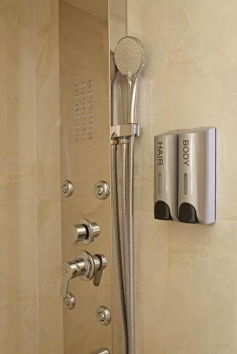 a shower door with a shower head on it at Cozyhome 4 ILISIA in Thessaloniki