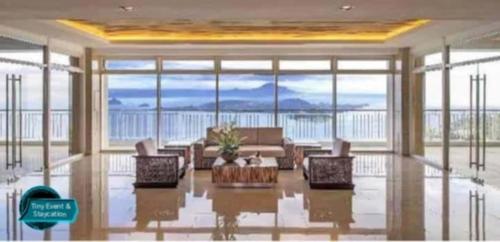 un salon avec un canapé et une grande fenêtre dans l'établissement SMDC Wind Residences Tagaytay City, à Kaybagal