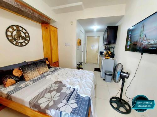 une chambre avec un lit et une télévision à écran plat dans l'établissement SMDC Wind Residences Tagaytay City, à Kaybagal