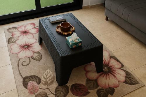 a black table with a ring on it on a rug at 819. 2BR Townhouse Sofa Bed TVs 2 Baths Garden in Sheikh Zayed