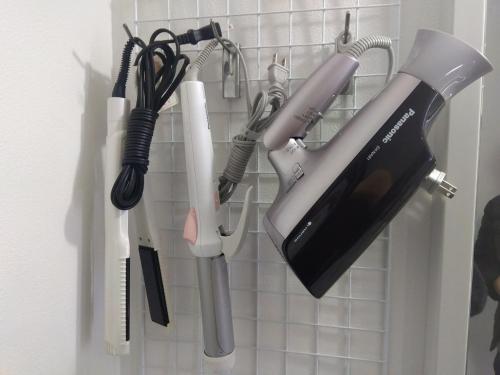 a hair dryer and other kitchen utensils hanging on a wall at Hotel HERMIT in Takamatsu