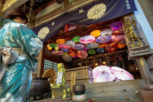 a woman standing in front of a store with umbrellas at HOTEL Villamure Ogori -ADULT ONLY- in Tosu