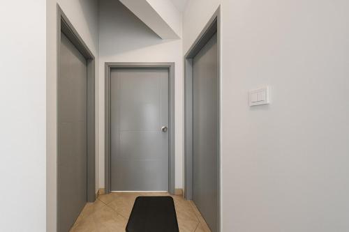 a hallway with a door and a black rug on the floor at 819. 2BR Townhouse Sofa Bed TVs 2 Baths Garden in Sheikh Zayed