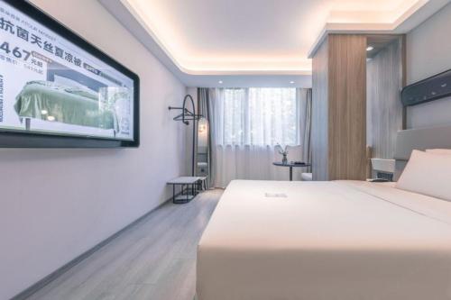 a hotel room with a bed and a flat screen tv at Atour X Hotel Shanghai Pudong Babaiban in Shanghai