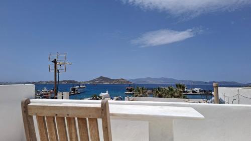 a wooden chair sitting on a balcony overlooking the water at Castellino Naxos in Naxos Chora