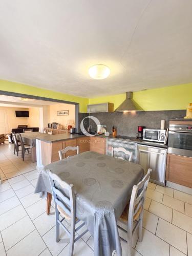 une cuisine avec une table et des chaises ainsi qu'une cuisine avec une table et un ordinateur dans l'établissement COC - Côte et Mer, à Wissant