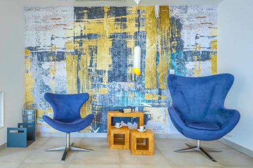 two blue chairs in a room with a wall at Villa Bellevue Bast in Baška Voda