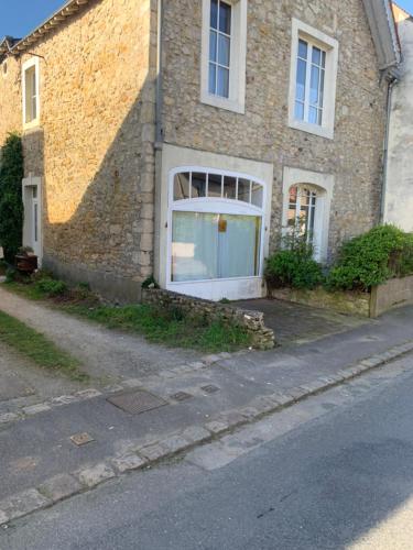 ein Backsteinhaus mit einem großen Fenster an der Seite in der Unterkunft Maison de charme in Malicorne-sur-Sarthe