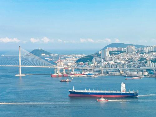 a large boat in the water next to a bridge at Brown Suites Busan Station in Busan