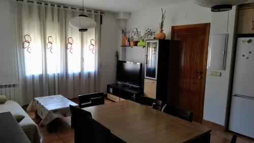 a living room with a table and a television at Apartamento Camarena de la Sierra in Camarena de la Sierra
