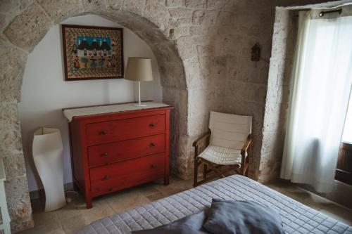 a bedroom with a bed and a dresser and a chair at Villa Catia in Alberobello