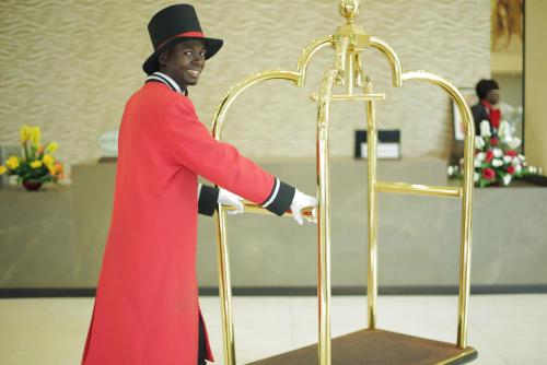 a man in a red suit and top hat next to a gold altar at GHS Hotel in Brazzaville