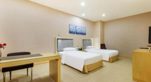 a hotel room with two beds and a desk at The Bauhinia in Shenzhen