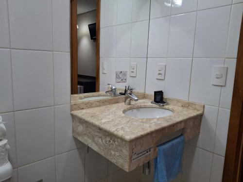 a bathroom with a sink and a mirror at Ônix Inn Hotel Cravinhos in Cravinhos