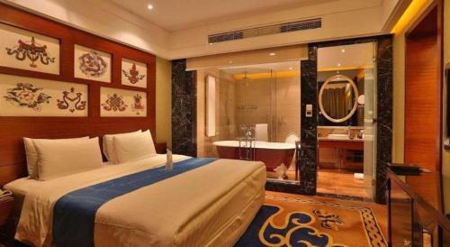 a bedroom with a bed and a tub and a bathroom at Hohhot Inner Mongolia Hotel in Hohhot