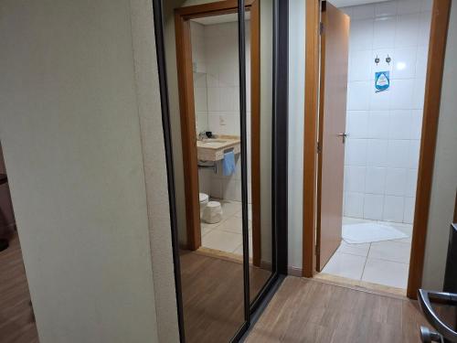 a bathroom with a mirror and a sink and a shower at Ônix Inn Hotel Cravinhos in Cravinhos