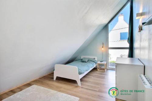 a small bedroom with a bed and a desk at Tresor du port in Sarzeau