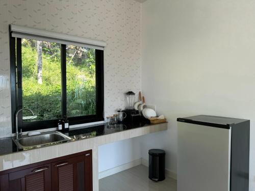 a kitchen with a sink and a window at Haad Yao Seaview Hut in Haad Yao
