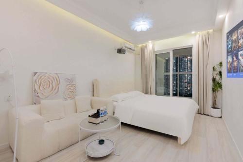 a white living room with a white couch and a table at Yupan Yunge Homestay (Jiefangbei Store) in Chongqing