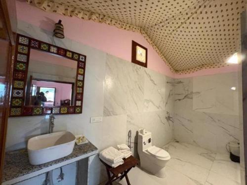 a bathroom with a sink toilet and a mirror at Atithi Luxury Resort in Pushkar