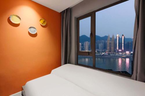 a bedroom with a window with a view of the city at Yupan Yunge Homestay (Jiefangbei Store) in Chongqing