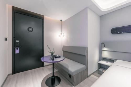 a small room with a table and a bed at Atour X Hotel Shanghai Pudong Babaiban in Shanghai