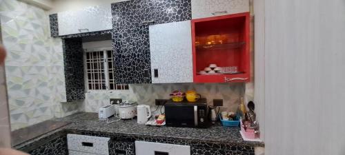 ハイデラバードにある2BHK AC Hitech City-Enjoy like your home Affordable Comfortableの電子レンジ付きのカウンタートップを備えたキッチン