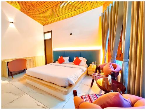 a bedroom with a bed and a table and chairs at NAINITAL HOTEL A LUXURIOUS RESORT'S PRANAV! INN - Free Parking & Wi-fi - Restaurant & Room Service - Spacious & Comfortable Rooms With Hill View Available -Near Bhowali Road - Best Hotel In Nainital in Bhowāli