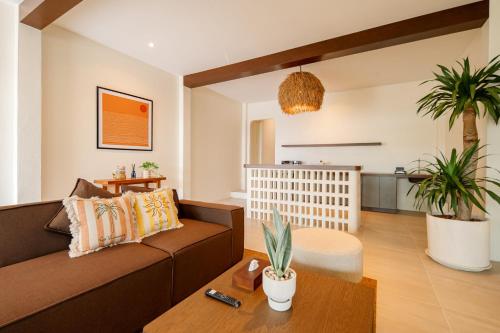 a living room with a brown couch and a table at SOL HOUSE kohlarn in Ko Larn