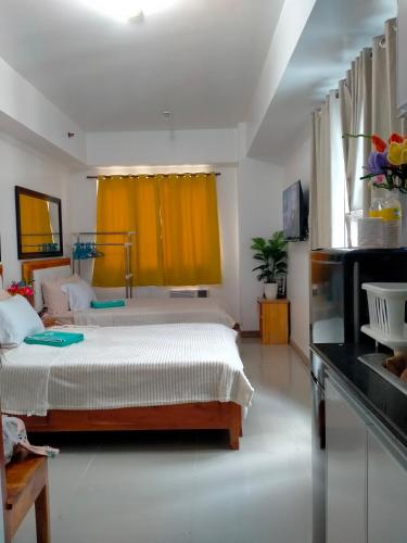 - une chambre avec un lit et un rideau jaune dans l'établissement Sea Residences Ace, à Manille
