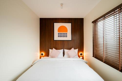 a bedroom with a large white bed and a window at SOL HOUSE kohlarn in Ko Larn