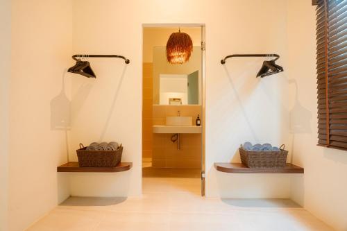 a hallway with two baskets and a mirror at SOL HOUSE kohlarn in Ko Larn