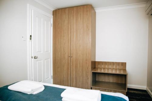 a bedroom with a bed and a wooden cabinet at Comfort Inn Moree in Moree