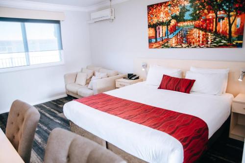a bedroom with a bed and a couch at Comfort Inn Moree in Moree