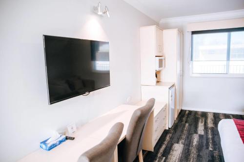 a white room with chairs and a tv on the wall at Comfort Inn Moree in Moree