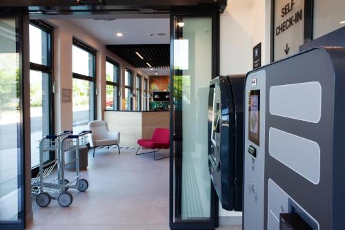 an empty lobby with a pay phone in a store at ibis budget Hotel Berlin Airport in Berlin
