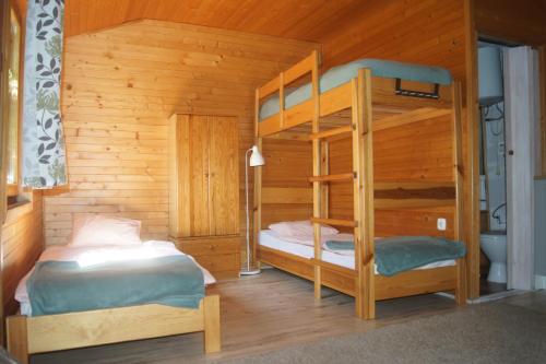a bedroom with two bunk beds in a cabin at Mały domek nad rzeką Słupią in Sulęczyno