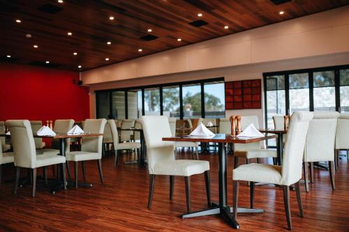 a dining room with tables and white chairs at Comfort Inn Moree in Moree