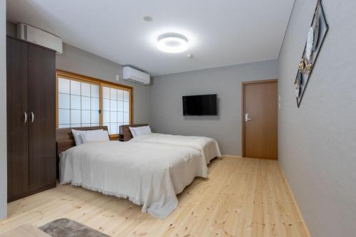 a bedroom with a bed and a flat screen tv at 御宿こだま in Matsumoto