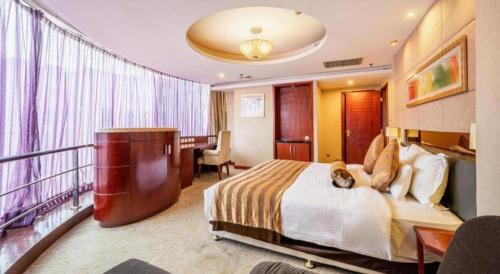 a hotel room with a large bed and a desk and a desk at Xian Union Alliance Atravis Executive Hotel in Xi'an
