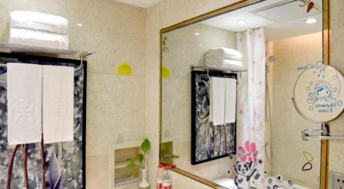 a bathroom with a sink and a large mirror at Changsha Huatian Hotel in Changsha