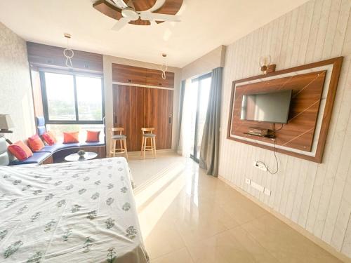 a bedroom with a bed and a tv on a wall at Vrindavan Elysia in Vrindāvan