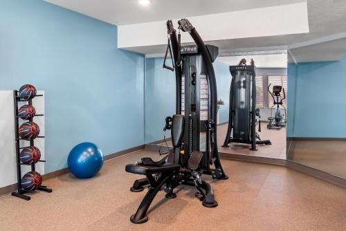 a gym with tread machines and a blue wall at WoodSpring Suites Greenville Airport in Greenville
