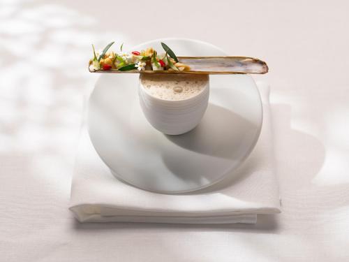 a plate with a salad on it with a knife on it at Cobergher Hotel in Kortrijk
