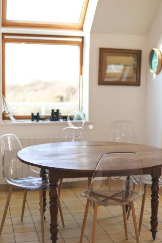 une table à manger avec deux chaises et une fenêtre dans l'établissement COC - Villa Le Grand Terrain - Vue Mer, à Wissant