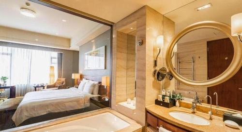 a bathroom with a bed and a tub and a mirror at Quanzhou Guest House Hotel in Quanzhou